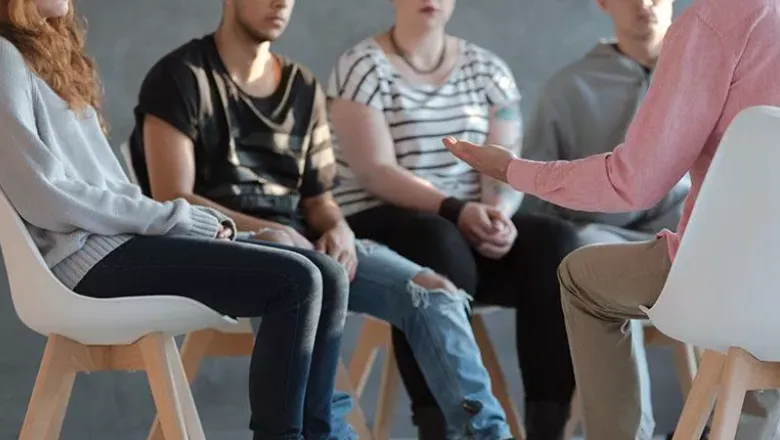 Group of people sitting on chairs in a circle