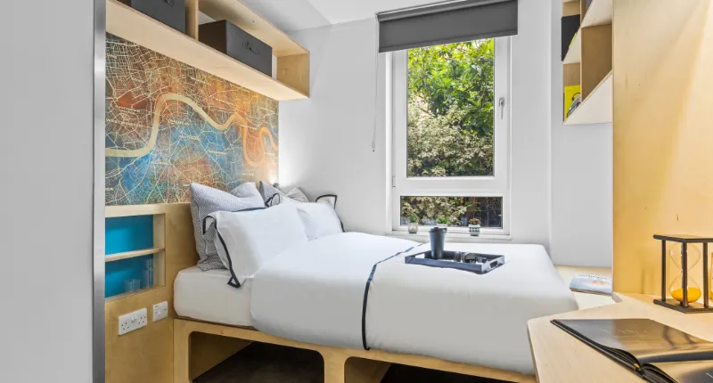 A room at Stanford Street Apartments, featuring a bed and a desk.
