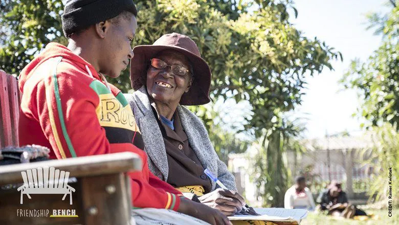 Grandmother conducting a problem solving therapy session with a young female client on the Friendship Bench  at a primary care clinic in Harare, Zimbabwe