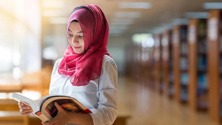 A woman reading a book in a library