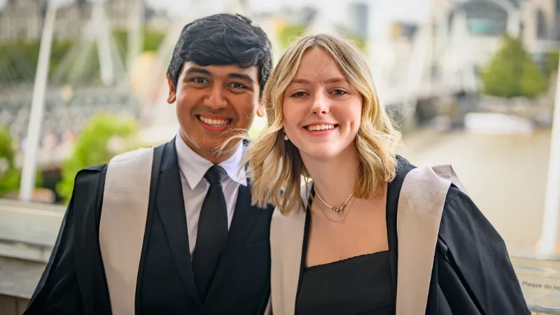 two students smiling on the terrace of royal festival hall