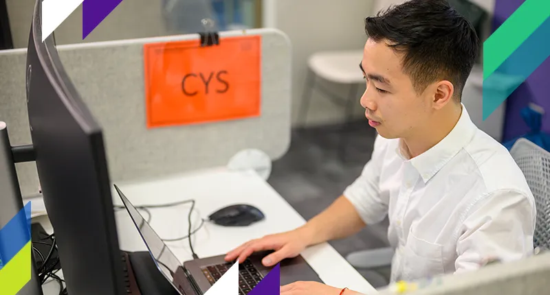 A young man works on his computer in a computer lab