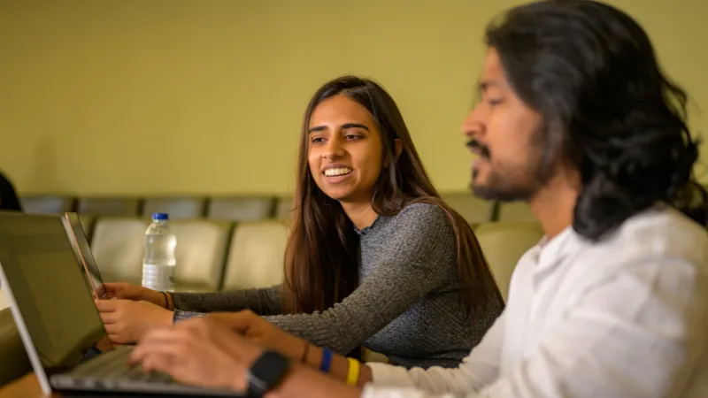 Two people looking at a laptop screen.