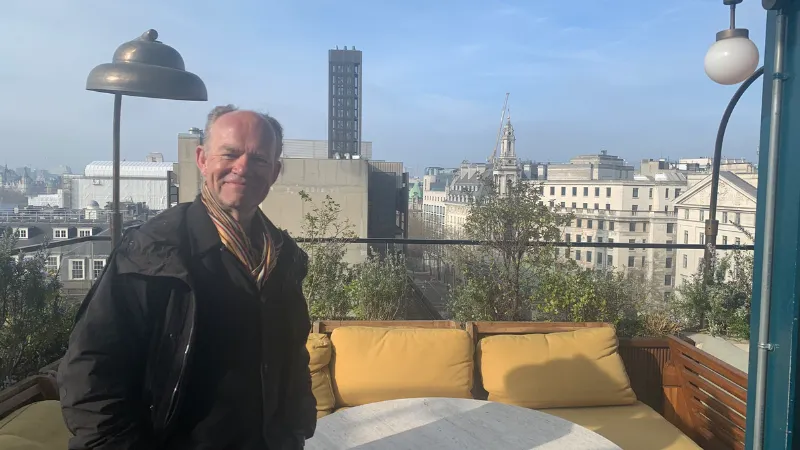 Professor Alan Read standing in front of a rooftop view